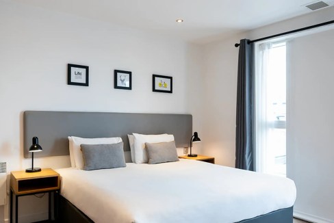 Comfortable hotel room with minimalist decor and natural light in Birmingham.