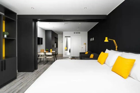 Modern hotel room at Venice Mestre Aparthotel with stylish black and yellow decor.