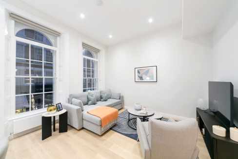Bright living room featuring large windows, comfortable sofa, and contemporary decor in a stylish ur.