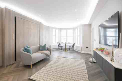 Spacious living room with bay windows, contemporary decor, and cozy seating area.