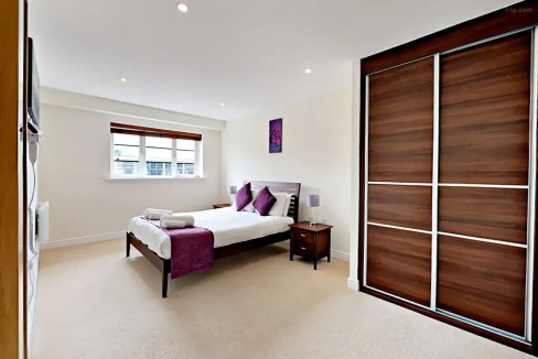 Bright, modern bedroom with a large window and stylish decor.