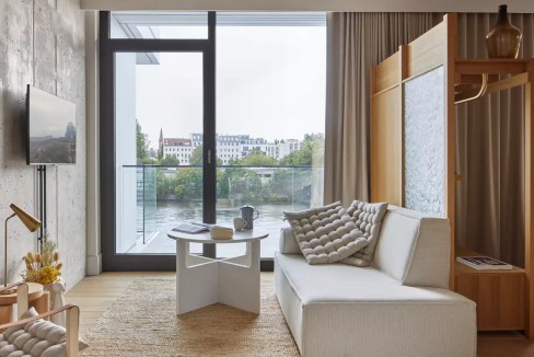 Contemporary living room at Berlin East Side Gallery Aparthotel with cityscape view.