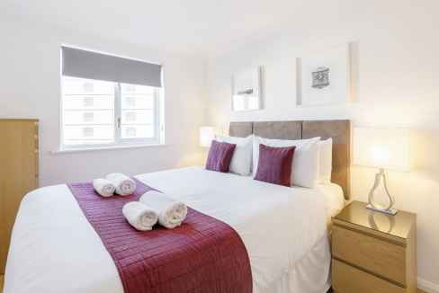 Bright bedroom in Kingston upon Thames apartment with modern decor and comfortable bedding.