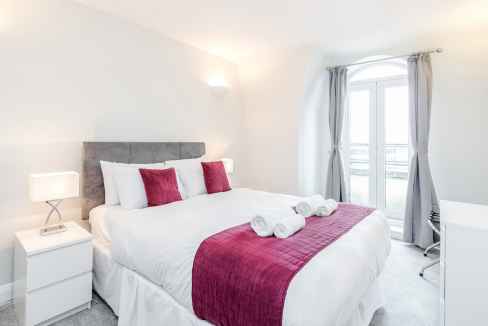 Comfortable bedroom with modern decor in Staines serviced apartments. Perfect for relaxing stays and.