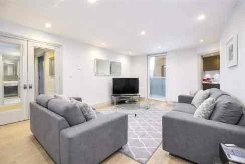 Spacious living room with two gray sofas and a flat-screen TV.