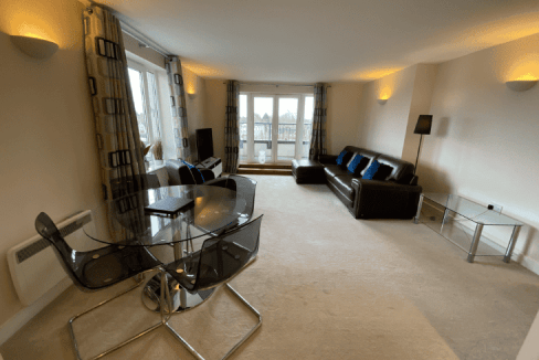 Spacious living room in Woking Stanley Rd Apartments with large windows and modern decor.