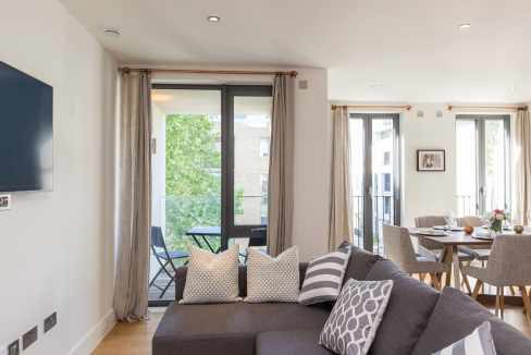 Modern living room in Portobello Road serviced apartments with balcony access.