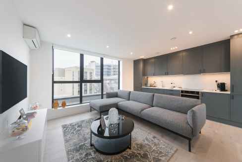 Spacious living room in Camden Chalk Farm Apartments featuring large windows and modern furnishings.
