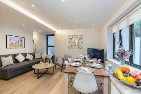 Modern Notting Hill serviced apartment living room with dining area and large windows.