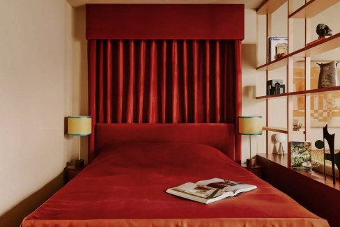 Cozy red bedroom with stylish decor at Zurich Enge Aparthotel, perfect for a comfortable stay.