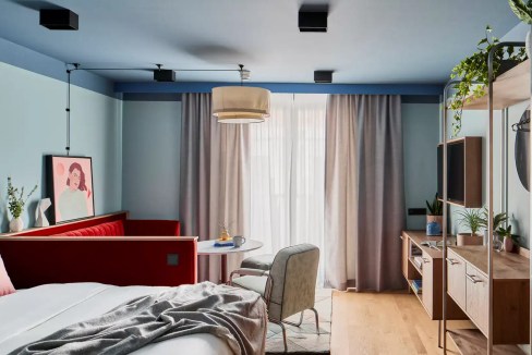 Apt hotel room in Munich with contemporary design, cozy bed, and bright ambiance.