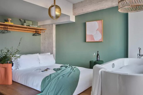 Stylish hotel room at Munich Gmunder Aparthotel with bathtub and contemporary decor.