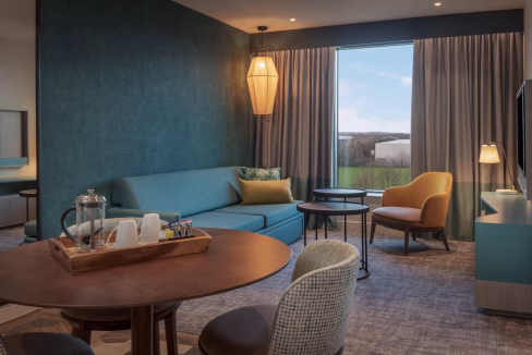 Heathrow Airport Aparthotel interior designed suite with plush modern furniture, neutral colours, and warm inviting lighting.