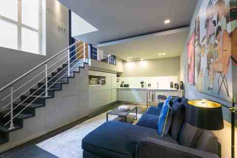 Stylish living room in Holborn Deluxe Apartments with modern furniture and vibrant artwork.