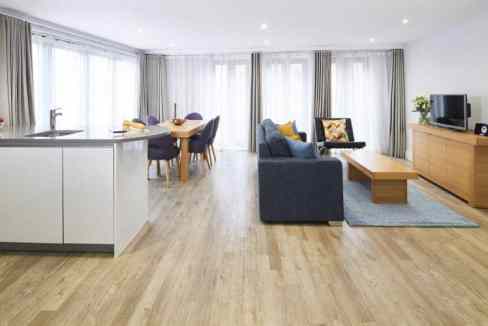 Modern living room with spacious seating and natural light at Great Tower Street Apartments.
