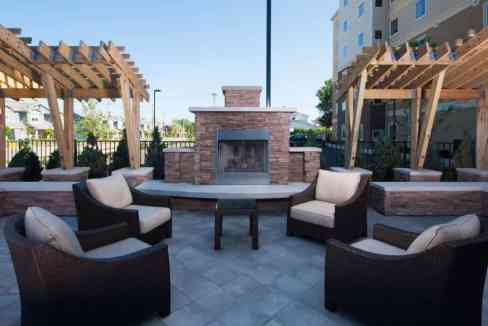 Outdoor seating with fireplace and pergolas at Buffalo Amherst Aparthotel.