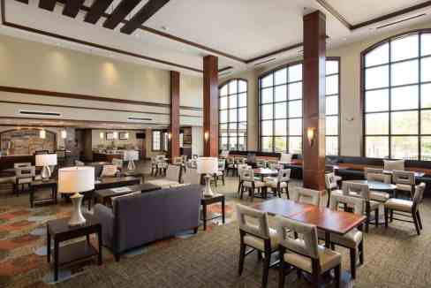 Spacious hotel lobby featuring large windows, contemporary furniture, and inviting seating areas.