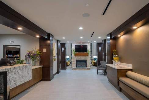 Elegant hotel lobby featuring a fireplace, comfortable seating, and contemporary decor.