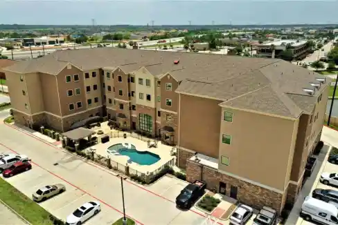 Aerial view of Houston Beltway Aparthotel with pool and parking area.