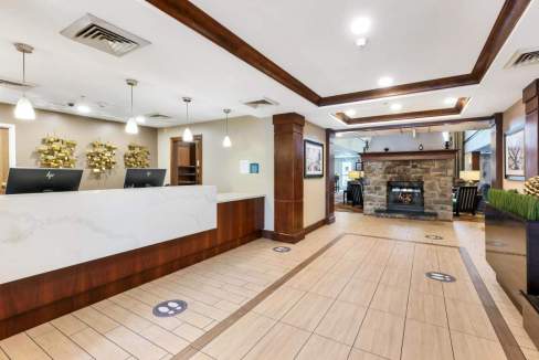 Modern hotel lobby with check-in counters, seating area, and stylish interior design.