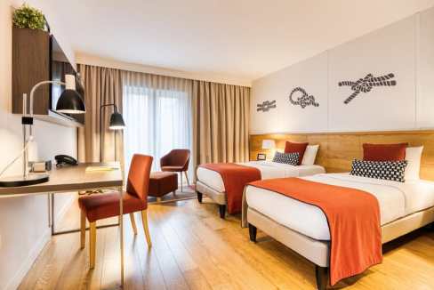 Comfortable hotel room with modern decor, two beds, and workspace at Hamburg City Centre Aparthotel.