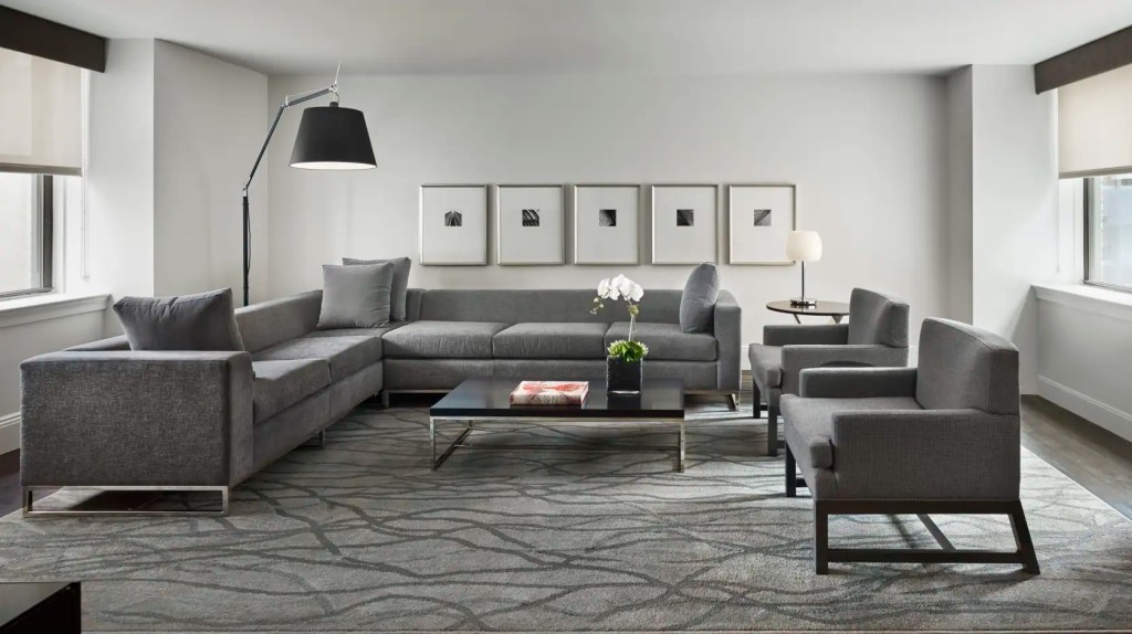 Contemporary living room with gray sofa, armchairs, and minimalist decor.