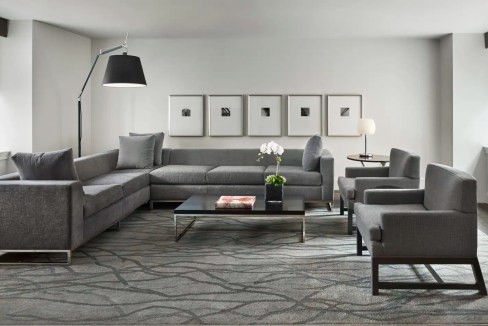 Contemporary living room with gray sofa, armchairs, and minimalist decor.