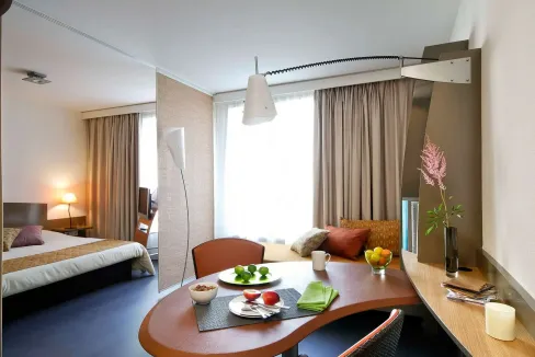 Bordeaux Gambetta Aparthotel room featuring a cozy dining space, large window with curtains, and con.