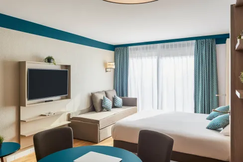 Hotel room with contemporary decor, large window, and cozy seating area at Beausoleil Monte Carlo Ap.