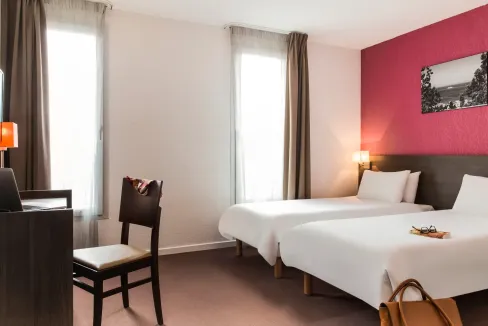 Modern hotel room with two beds and natural light in Marseille Saint-Charles area.