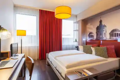 Stylish hotel room in Berlin Charlottenburg with contemporary furnishings and vibrant accents.