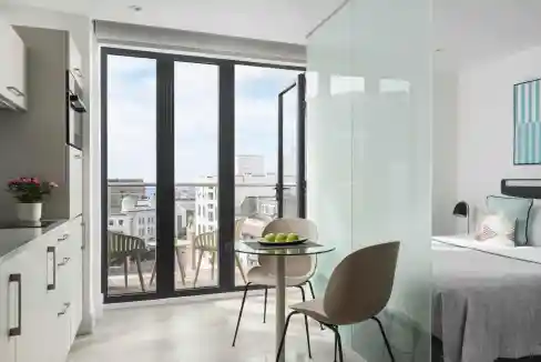 Modern apartment interior with balcony overlooking Brighton cityscape.