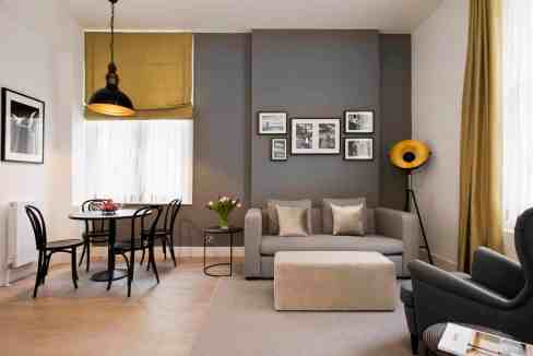 Spacious living room with stylish decor, comfortable sofa, and dining table at Kensington Nevern Pla.