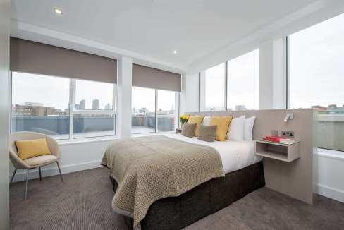 A stylish bedroom in London Clerkenwell Aparthotel featuring large windows, contemporary decor, and.