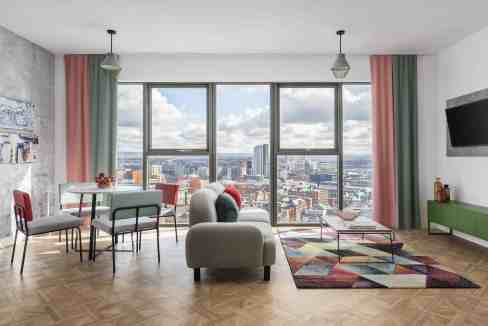 Bright living room with city skyline view in Manchester Aparthotel.