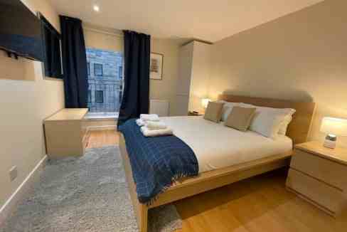 Modern Glasgow Bell Street Apartments bedroom with cozy decor and city views.