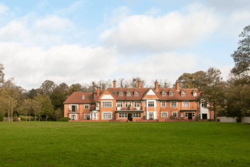 Large historic apartment building on lush green lawn in Staines Ferry Lane area.