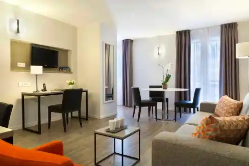 Aparthotel living room in Montpellier Antigone with contemporary furniture, bright windows, and cozy.