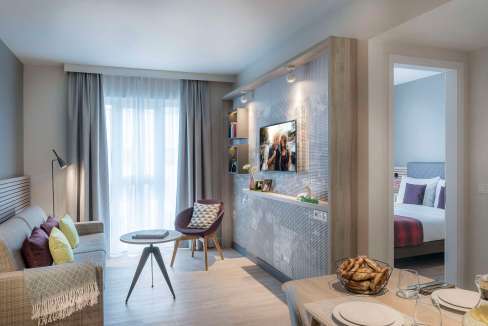 Stylish Munich Aparthotel living room with contemporary decor and cozy seating.