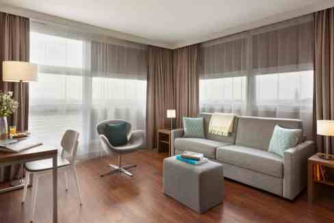 Spacious living area at Lille Westfield Euralille Aparthotel featuring contemporary furniture and pa.