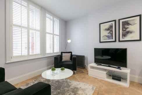 Bright Soho Shaftesbury Avenue apartment living room with large windows and contemporary decor.