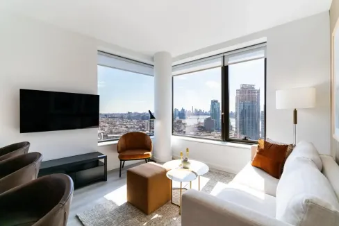Bright living room in Brooklyn Greenpoint with large windows and skyline scenery.