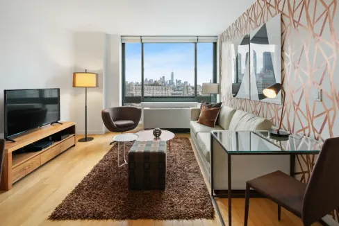 Urban apartment interior with large window overlooking Manhattan skyline.
