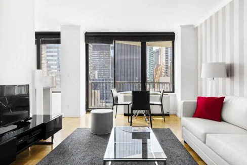 Apartment living room with large windows and city views in Manhattan Tramway Plaza.