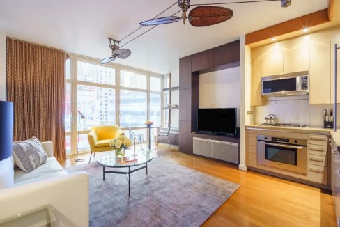 Spacious New York Broadway apartment living room with modern furniture and city views.