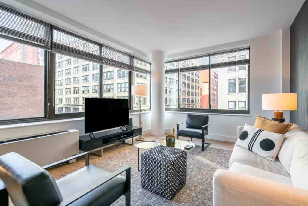 Bright living room in Greenwich Village apartment with large windows and city views.