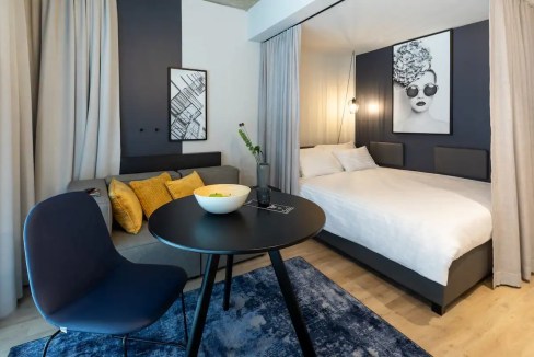 Contemporary hotel room at Vienna Central Station featuring a cozy bed, artwork, and modern furnishi.