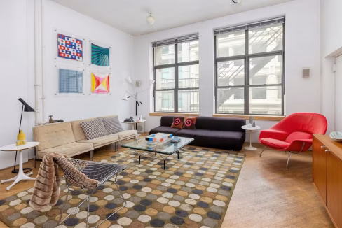 Light-filled living room in Soho Vintage Loft with geometric rug and red sofa