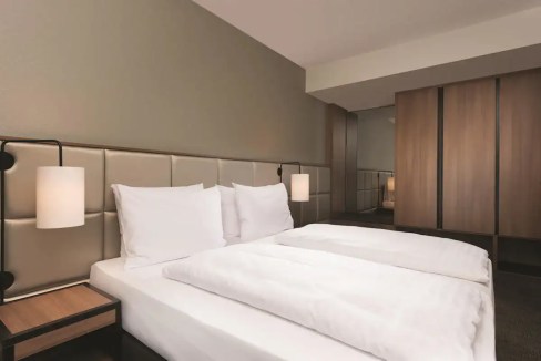 Modern hotel bedroom with comfortable bed and contemporary decor at Frankfurt Guterplatz Aparthotel.