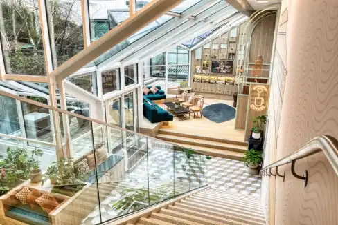 Bright interior with glass walls and cozy seating area at Paris Les Halles Aparthotel.